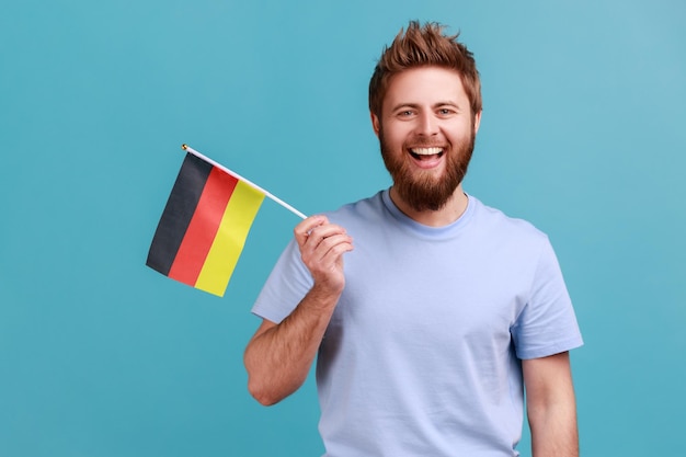 Mann mit Deutschland-Flagge, der am 3. Oktober den Deutschlandtag feiert und positive Emotionen ausdrückt