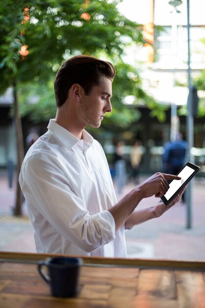 Mann mit digitaler Tablette am Schalter