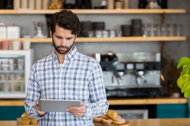 Mann mit digitaler Tablette im Café