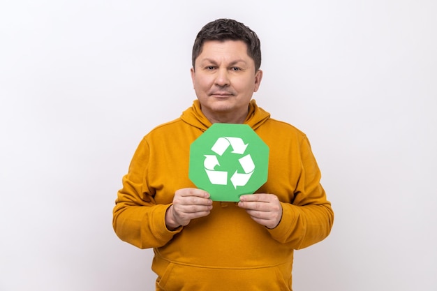 Mann mit dunklem Haar, das das Recyclingsymbol für grüne Abfälle zeigt, zufrieden mit der Umweltsicherheit