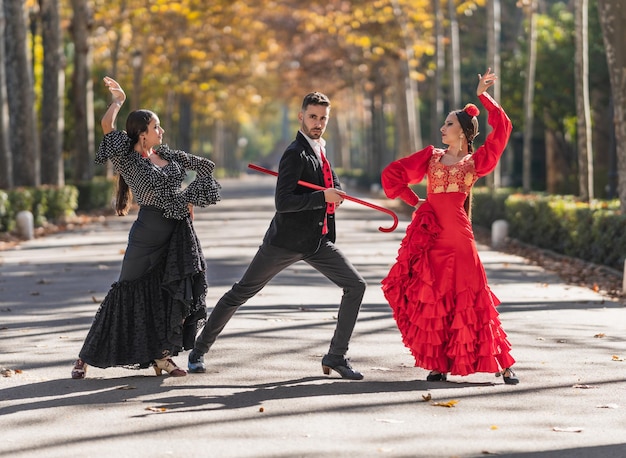 Mann mit ein paar Flamenco-Tänzerinnen tanzen in einem Park in Sevilla