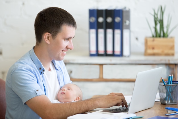 Foto mann mit einem baby und einem laptop