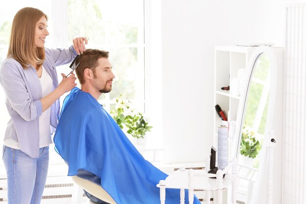 Mann mit einem Haarschnitt von einer Friseurin im Salon