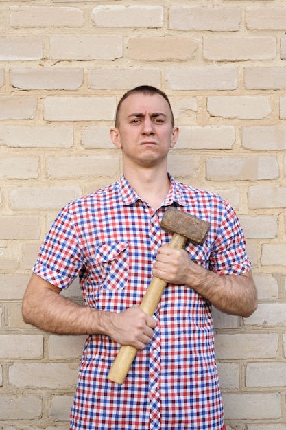 Mann mit einem Hammer auf der Mauer