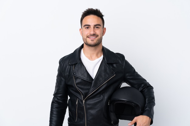 Mann mit einem Motorradhelm, der mit den Armen an der Hüfte aufwirft und lächelt