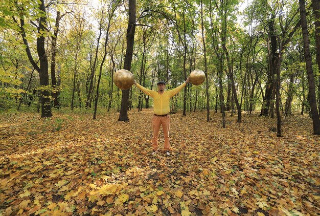 Mann mit einem seltsamen goldenen Kugelkopf im Wald