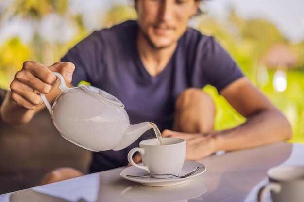 Mann mit einer Tasse Tee auf der Veranda des Cafés in der Nähe der Reisterrassen auf Bali Indonesien