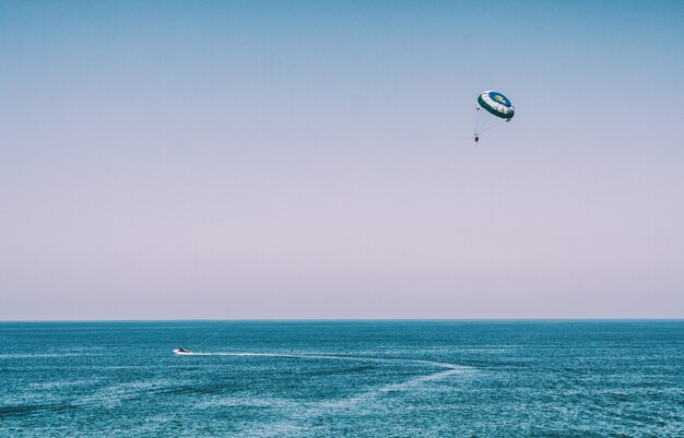 Mann mit Fallschirm am Meer