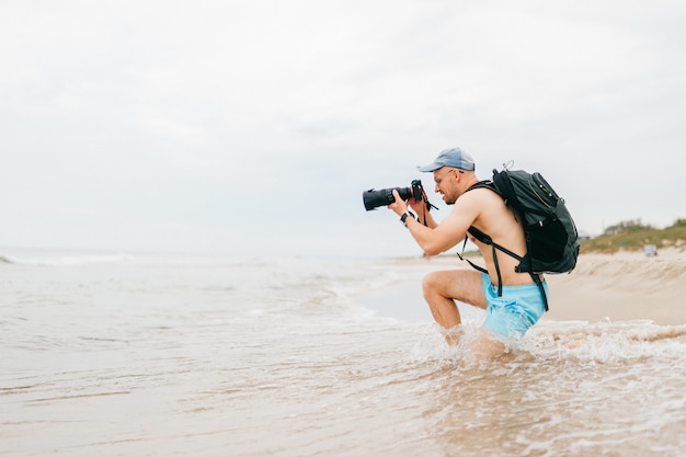 Mann mit Fotokamera, die das Meer fotografiert