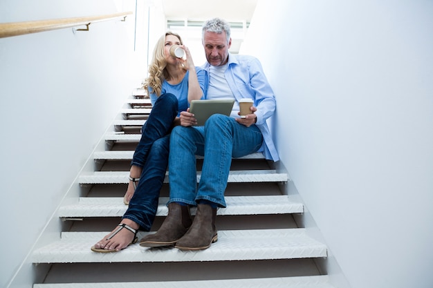 Mann mit Frau, die digitales Tablett hält