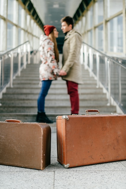 Mann mit Freundin, Koffer warten auf Zug auf Treppe.