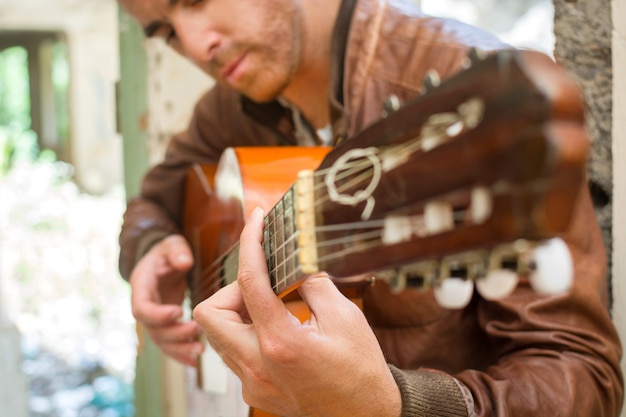 Mann mit Gitarre in einem zerstörten Gebäude urbanen Stil