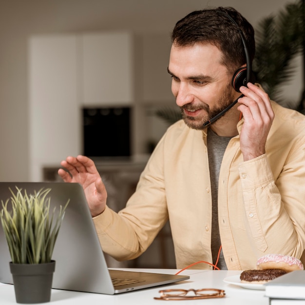 Foto mann mit headset, der videoanruf auf laptop hat