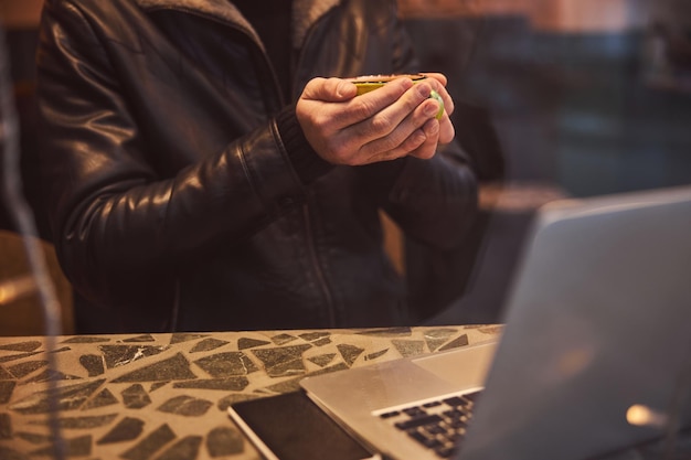 Mann mit heißem Getränk und Notizbuch im Café