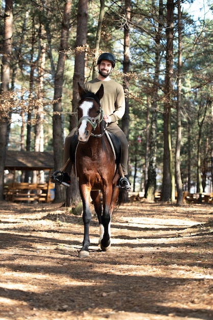 Mann mit Helm auf einem Pferd im Wald