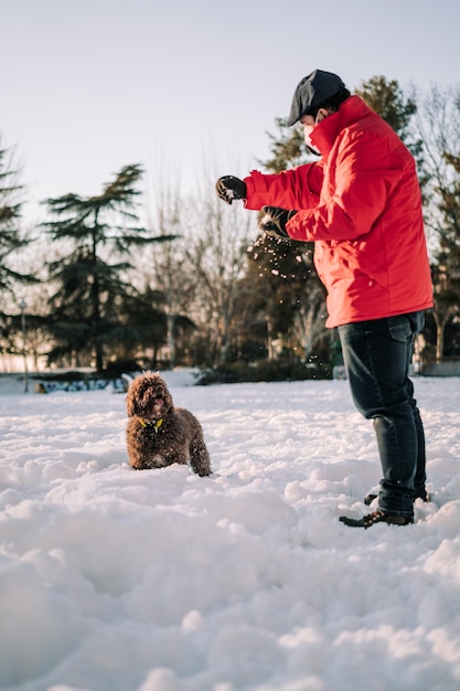 Foto mann mit hund auf schnee