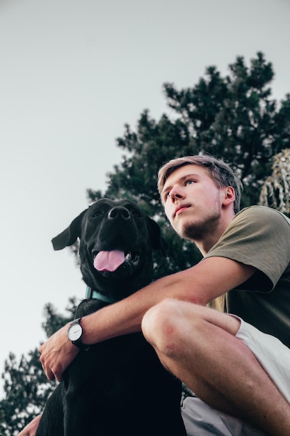 Mann mit Hund gegen den Himmel