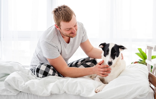 Mann mit Hund im Bett