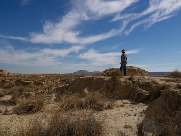 Foto mann mit hut in der wüste blickt auf die unendlichkeit bardenas reales navarra spanien