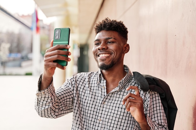 Mann mit Jacke über der Schulter, der ein Selfie macht