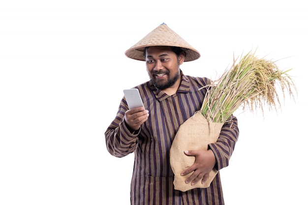 Mann mit javanischem traditionellem lurik Hemd, das Reiskörner hält