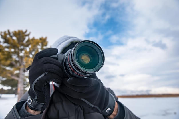 Mann mit Kamera in verschneiter Natur