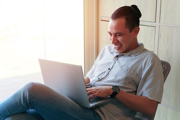 Mann mit Laptop-Computer beim Sitzen im Wohnzimmer