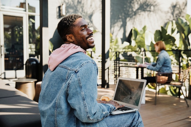 Mann mit Laptop in einem Café