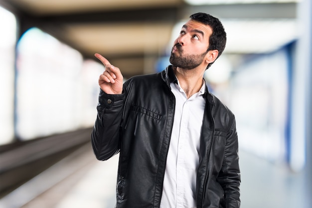 Mann mit Lederjacke denken auf unfocused Hintergrund