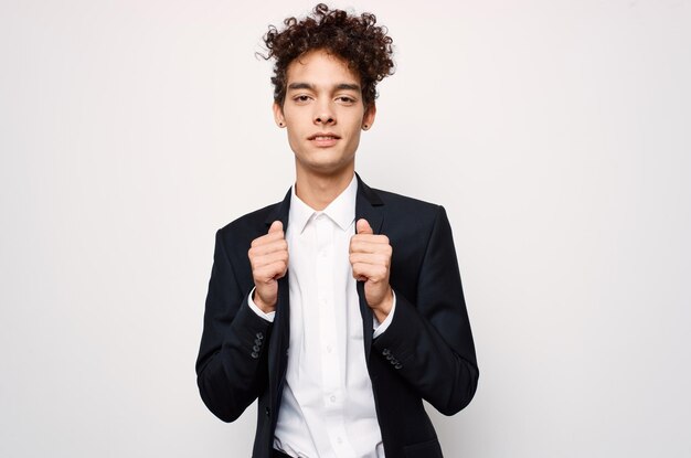 Mann mit lockigem Haar in einem Anzug, modischer schwarzer Blazer, moderner Stil, hochwertiges Foto