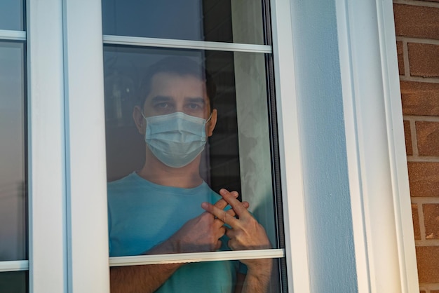 Mann mit Maske durch das Fenster gesehen