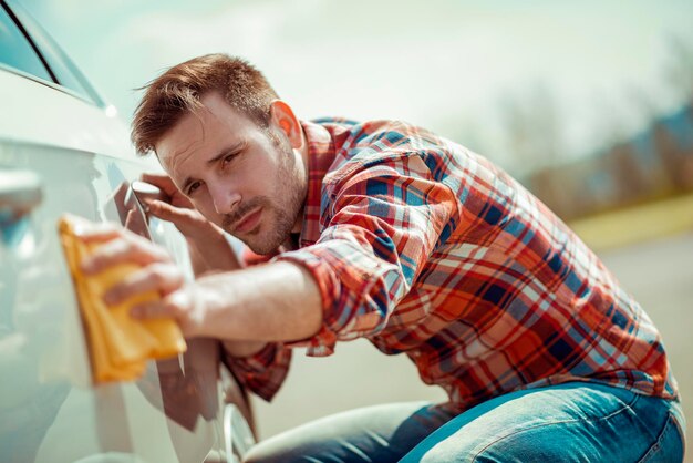 Foto mann mit mikrofaser wischt das autopolieren ab