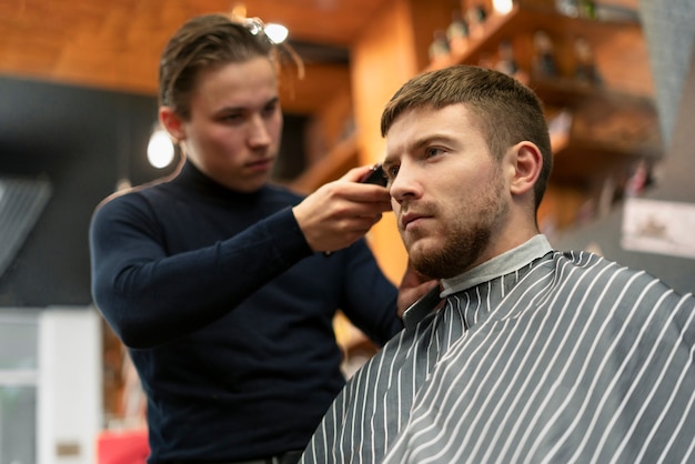 Mann mit mittlerem Schuss bekommt Haarschnitt