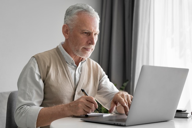 Mann mit mittlerem Schuss, der auf Laptop tippt