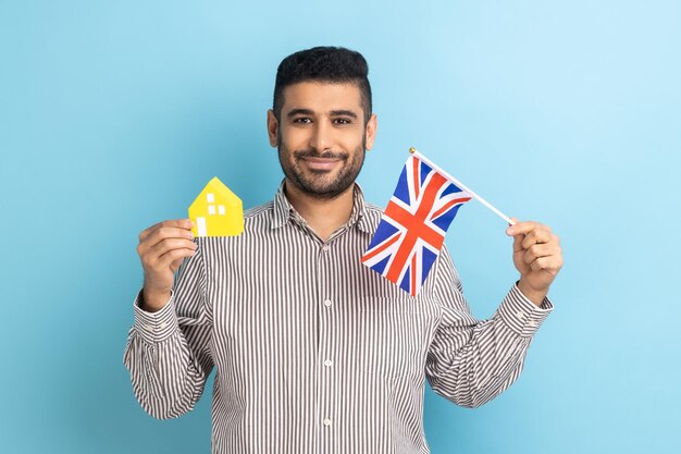 Mann mit Papierhaus und Flagge der britischen Einwanderung und Hauskauf in England