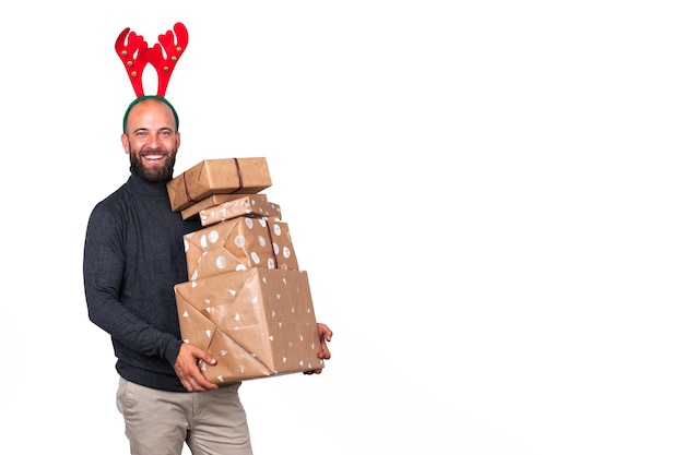 Mann mit Rentiergeweih, der in die Kamera schaut, trägt Weihnachtsgeschenke Weißer Hintergrund Textfreiraum