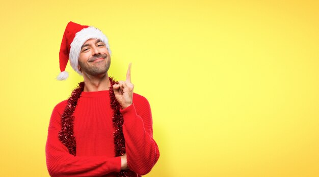 Mann mit roter Kleidung feiert die Weihnachtsfeiertage, die einen Finger zeigen und anheben