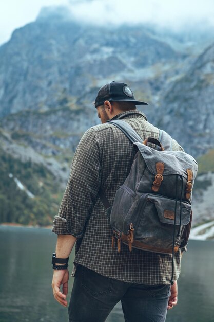 Mann mit Rucksack am See im Bergwanderkonzept