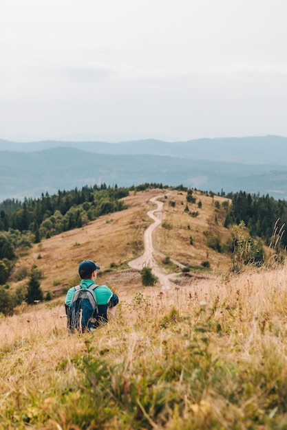 Mann mit Rucksack, der durch Herbstberge wandert