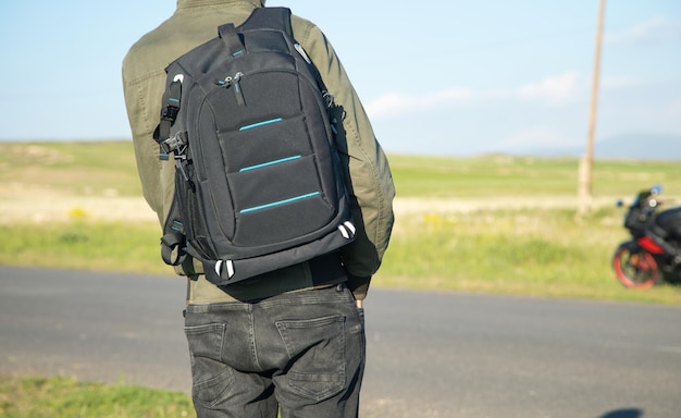 Foto mann mit rucksack steht auf der straße