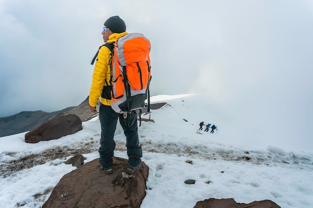 Mann mit Rucksack Trekking in den Bergen Kaltes Wetter Schnee auf Hügeln Winterwandern