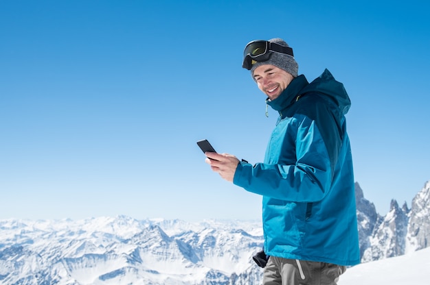 Mann mit Smartphone im Berg