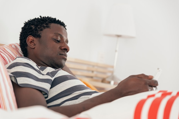 Mann mit Smartphone im Bett