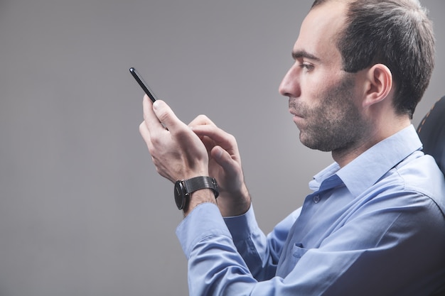 Mann mit Smartphone im Büro.