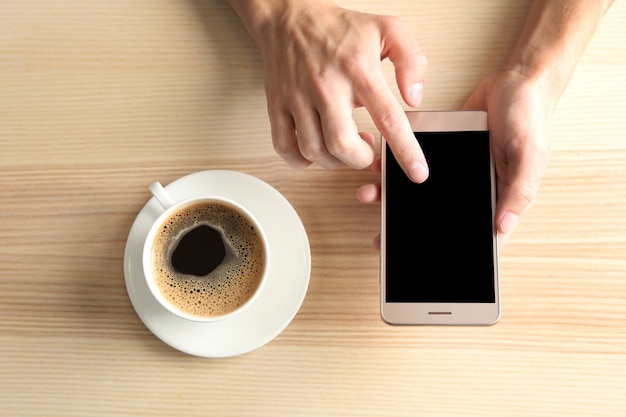 Mann mit Smartphone im Café