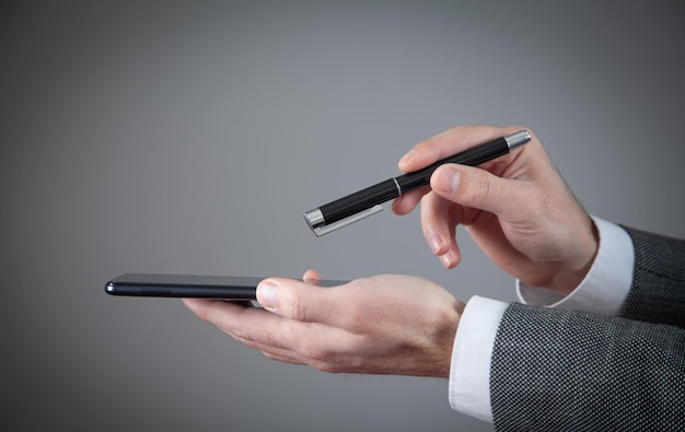 Mann mit Stift und Smartphone Technologiekonzept