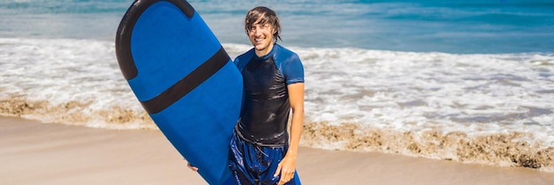 Mann mit Surfbrett über dem Kopf Nahaufnahme eines hübschen Kerls mit Surfbrett auf dem Kopf am Strand