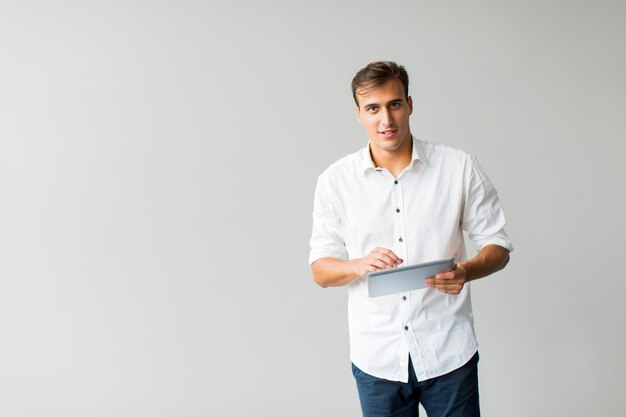 Mann mit Tablet an der Wand