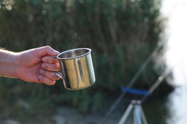 Foto mann mit tasse in der hand das abenteuer beginnt mit reisen, angeln und camping