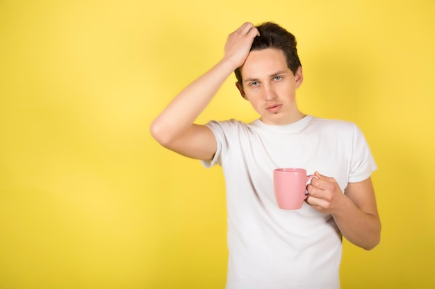 Mann mit Tasse Kaffee auf gelbem Hintergrund